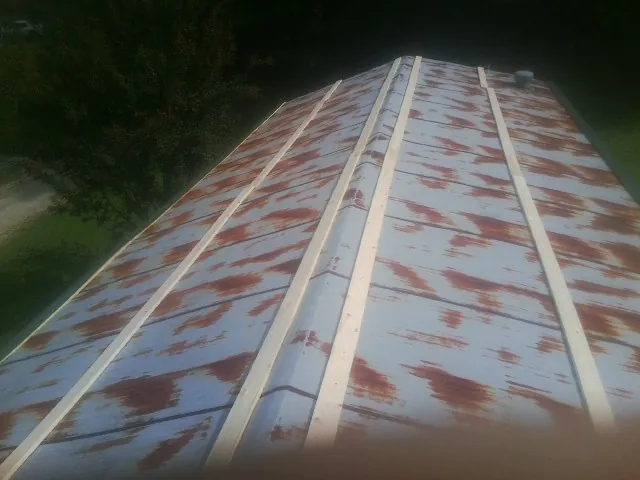 Rusted metal roof panels with new wood purlins before replacement — Storm Damage Roof Repair in Ohio City by Roofing Brothers