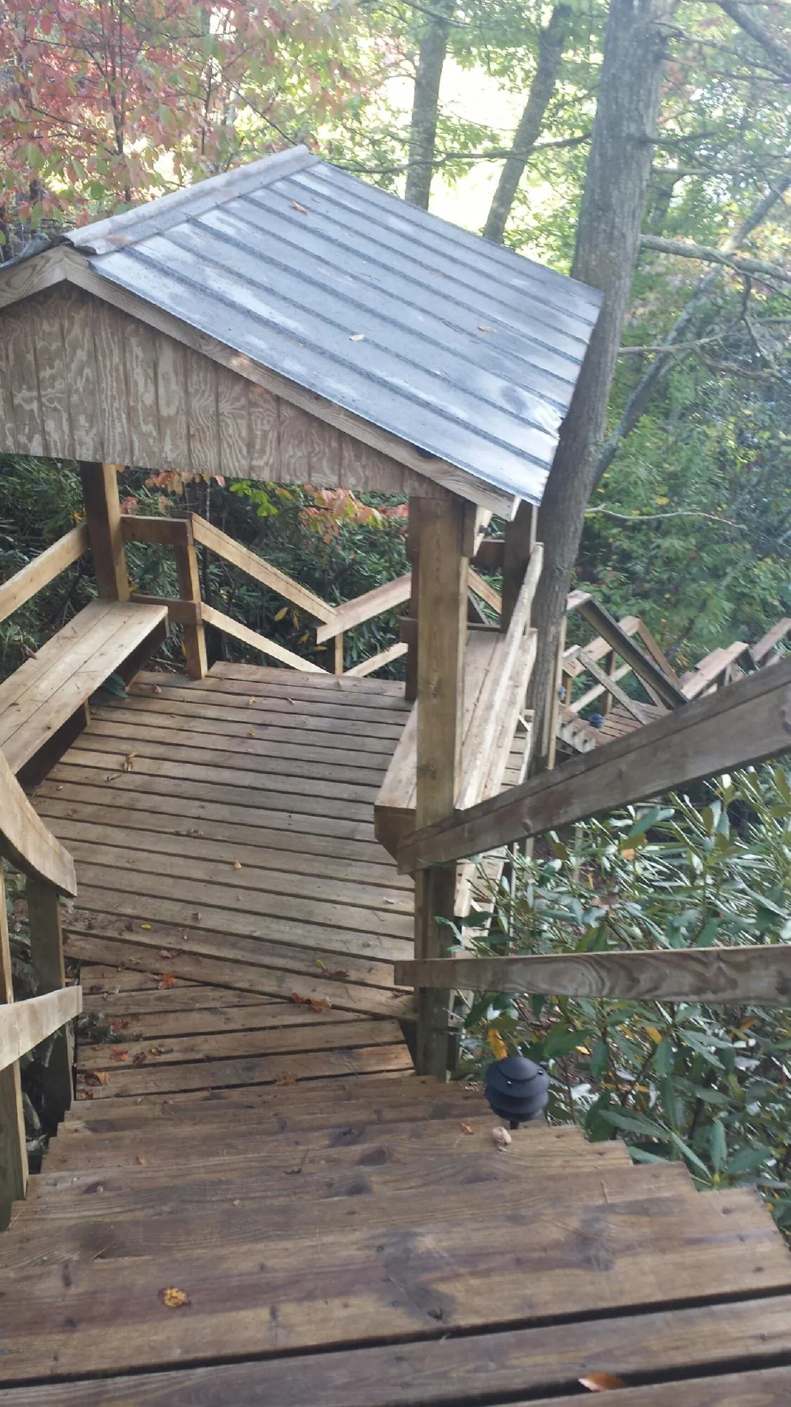 Metal roofed shelter over wooden steps on a wooded walkway — Skylight Repair & Installation work by our crew in Ohio City
